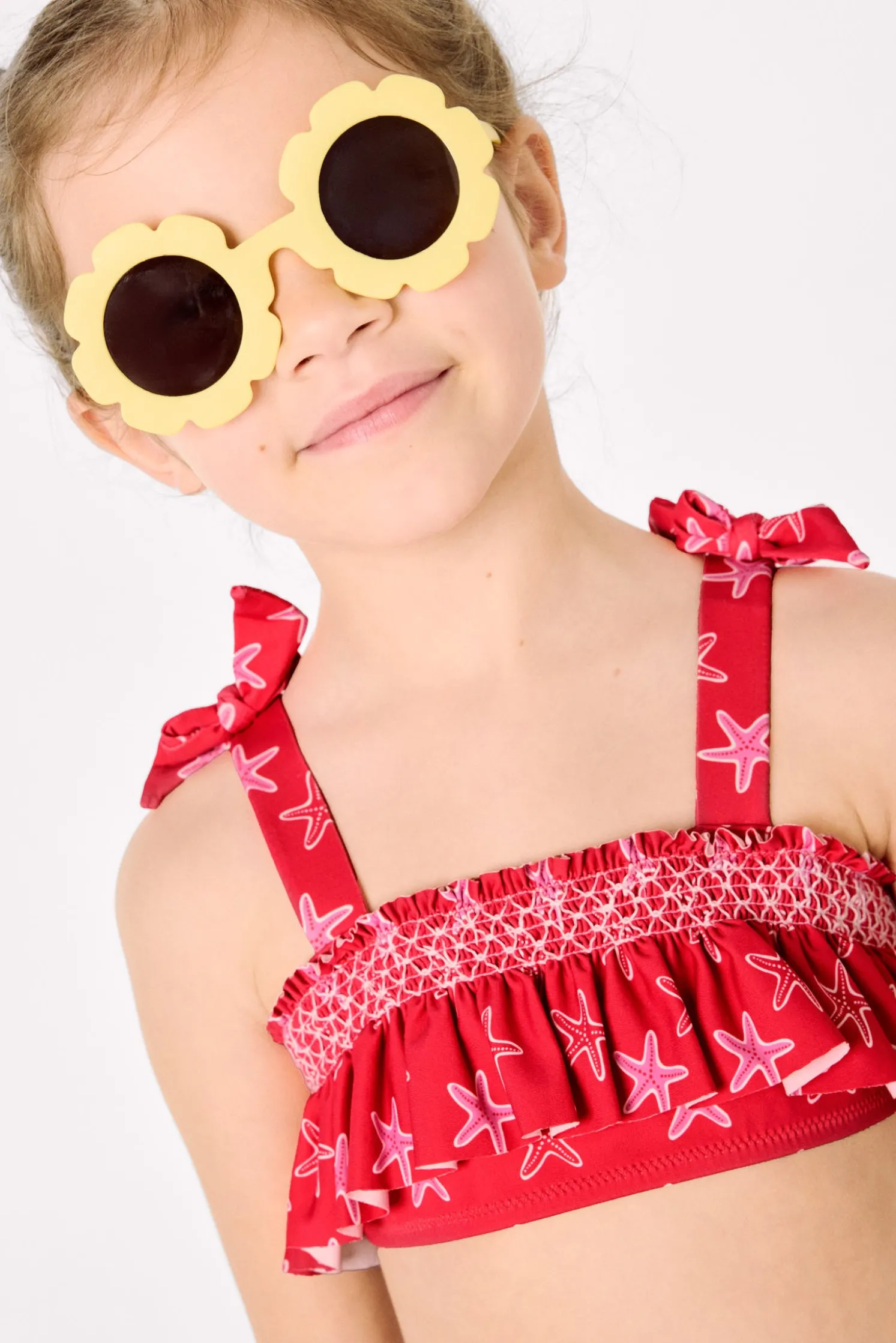 Bikini niña detalles volantes y nido de abeja estampado estrellas marinas rojo
