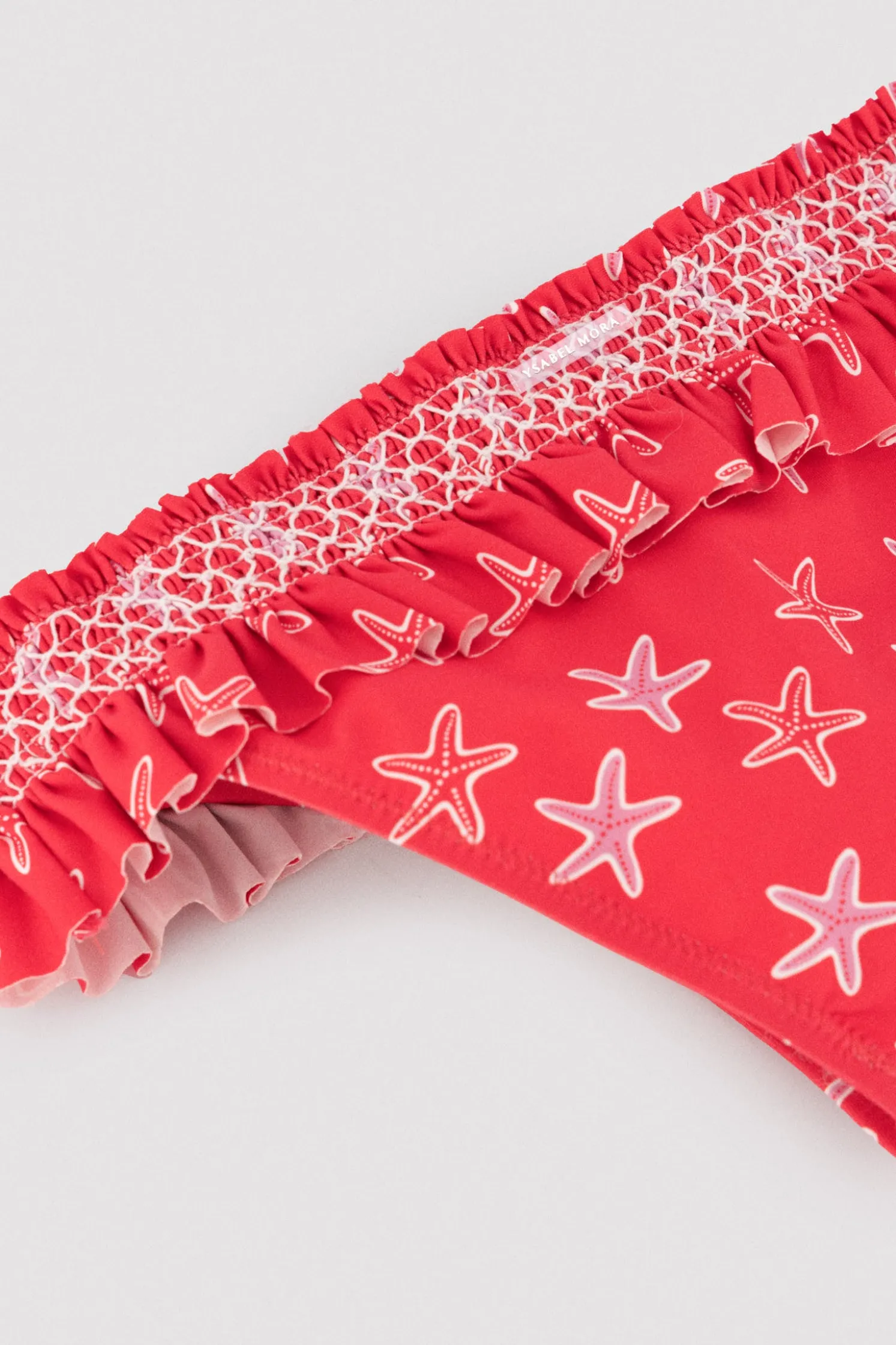 Bikini niña detalles volantes y nido de abeja estampado estrellas marinas rojo