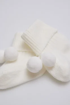 Calcetines canalé con borlas recién nacido marfil