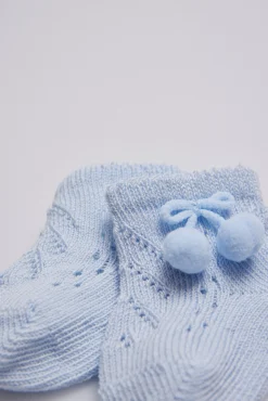 Calcetines perlé con borlas recién nacido celeste