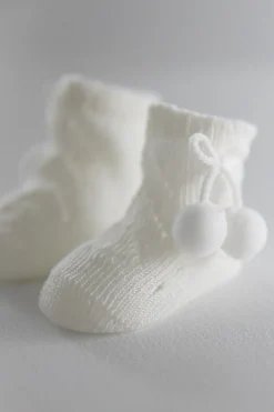Calcetines perlé con borlas recién nacido marfil